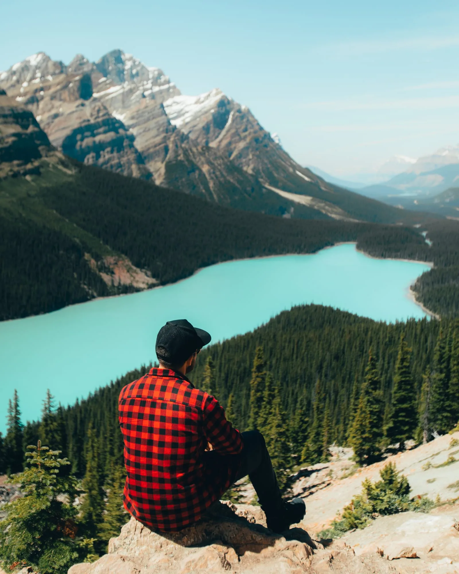 Alex sitting above a turquoise alpine lake