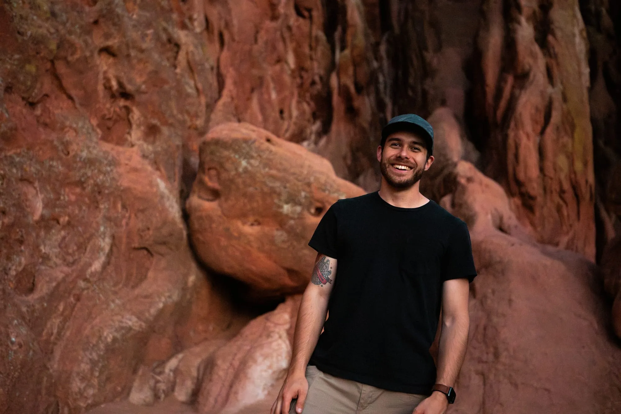 Alex leaning against red rock in the desert Southwest